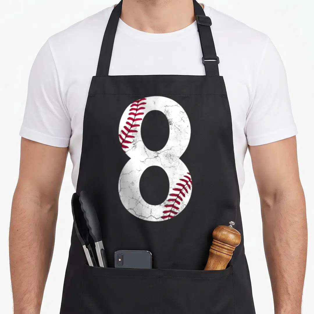Birthday baseball apron - Number 8 shaped like a baseball with white and red stitching details — shown on a black cotton canvas apron against a white background