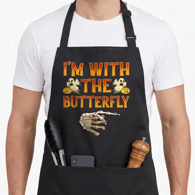 Costume butterfly apron - I'm With The Butterfly text, skeleton hand, two ghosts, two pumpkins, orange cartoon art — shown on a black cotton canvas apron against a white background