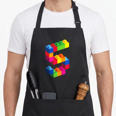 Brick block & apron - Number 5 constructed from blue red green yellow orange pink toy bricks — shown on a black cotton canvas apron against a white background