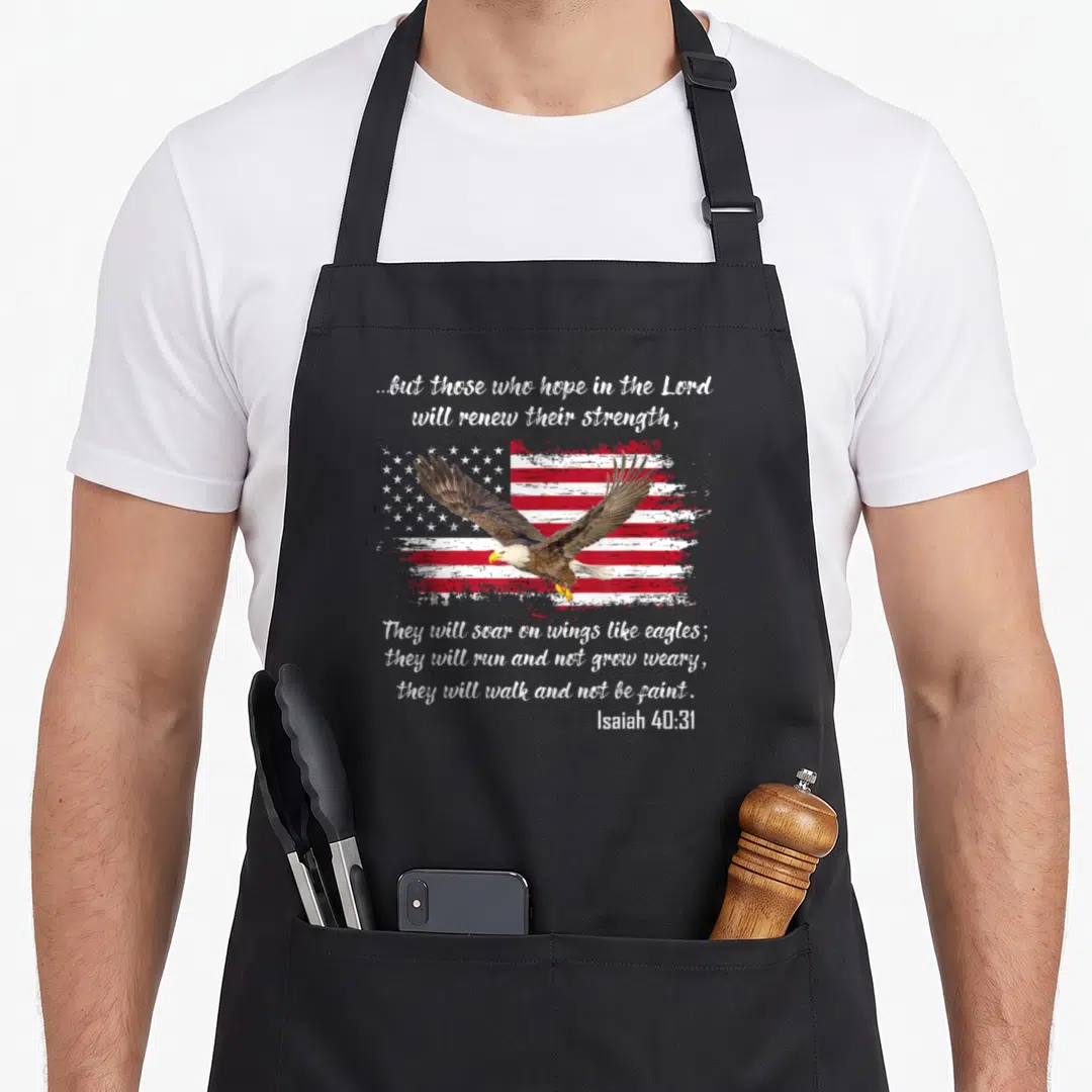 Holy bible verse apron - Eagle flying over distressed flag with Isaiah 40:31 scripture text — shown on a black cotton canvas apron against a white background