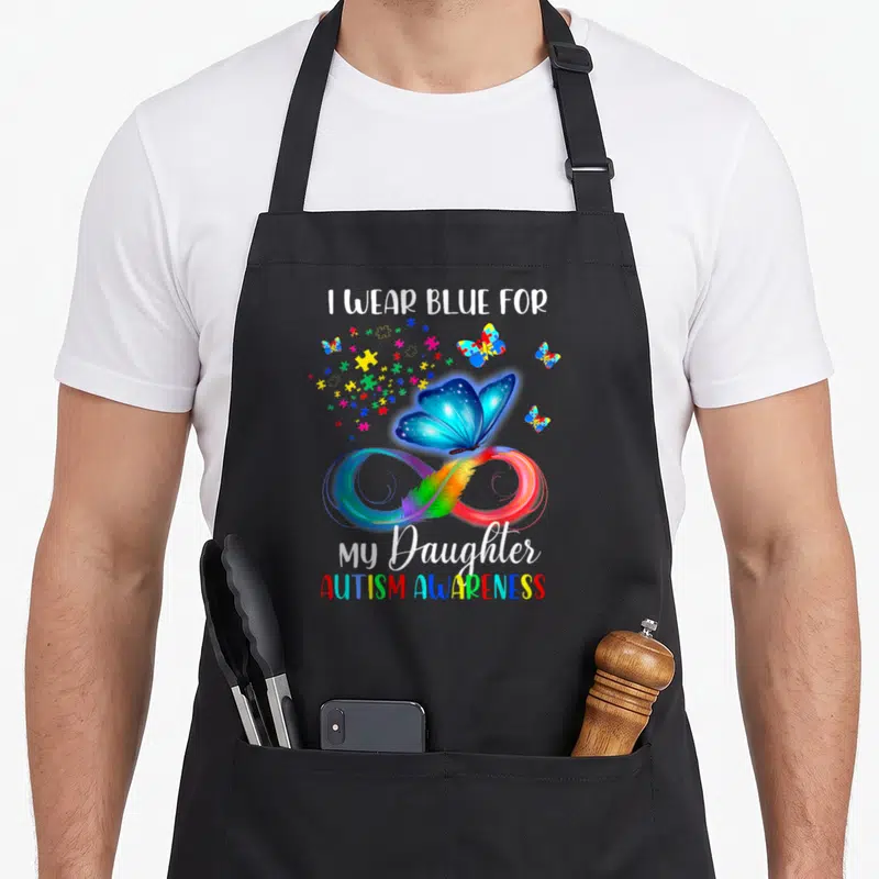 Blue mom daughter apron - Blue butterfly above rainbow infinity with feather, puzzle pieces, and autism awareness text — shown on a black cotton canvas apron against a white background
