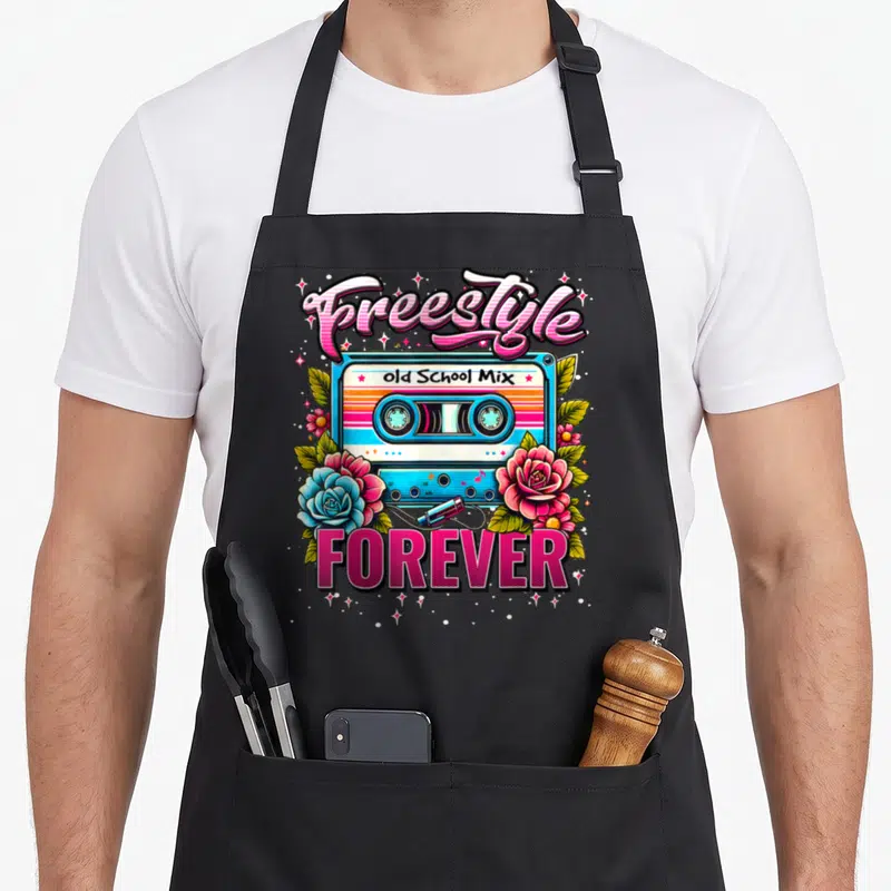 Perfect 80s apron - Retro cassette tape with Freestyle Old School Mix text and pink blue roses — shown on a black cotton canvas apron against a white background