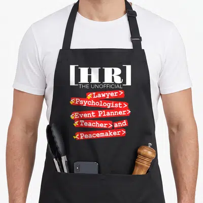Unofficial hr apron - Text reading HR the unofficial lawyer psychologist event planner teacher and peacemaker with red — shown on a black cotton canvas apron against a white background