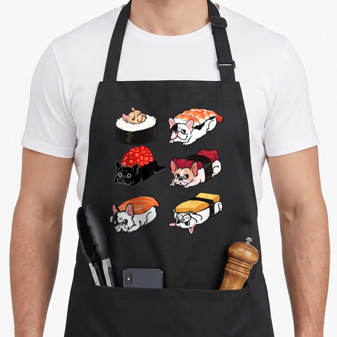 Sushi french bulldog apron - Six cartoon french bulldogs dressed as sushi rolls in white, black, orange, red, and yellow — shown on a black cotton canvas apron against a white background