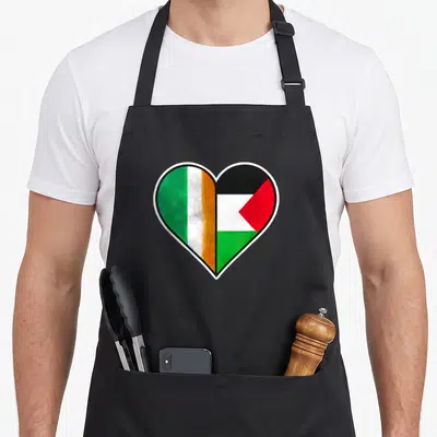 Palestine ireland apron - Heart shape split with Irish and Palestinian flag colors green white orange black red — shown on a black cotton canvas apron against a white background