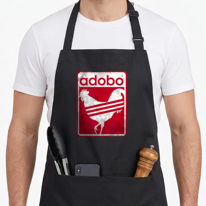 Distressed chicken apron - Red and white rooster silhouette with adobo text in distressed retro style — shown on a black cotton canvas apron against a white background