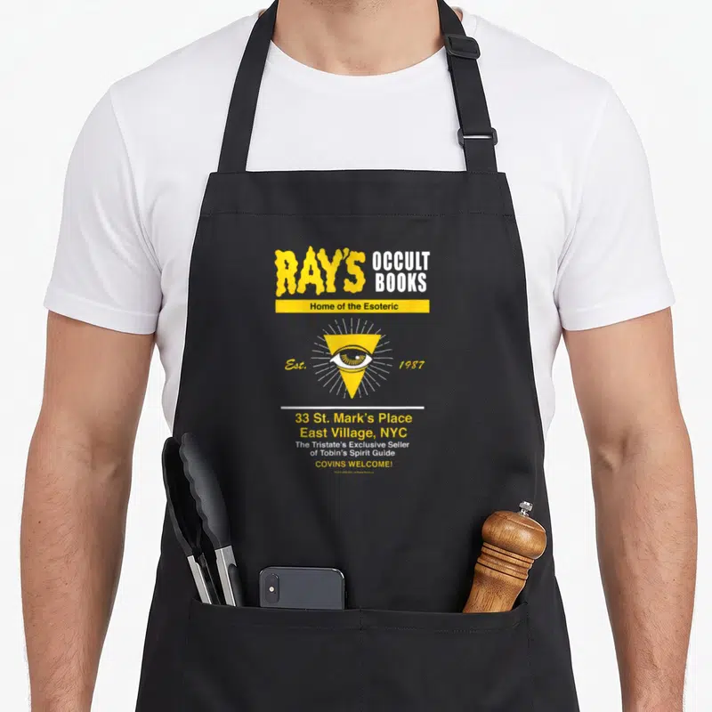 Ray novelty apron - Eye in yellow triangle with Ray's Occult Books text and NYC address — shown on a black cotton canvas apron against a white background