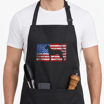 Dane 4th of july apron - Distressed USA flag background with a grey Great Dane silhouette cutout — shown on a black cotton canvas apron against a white background