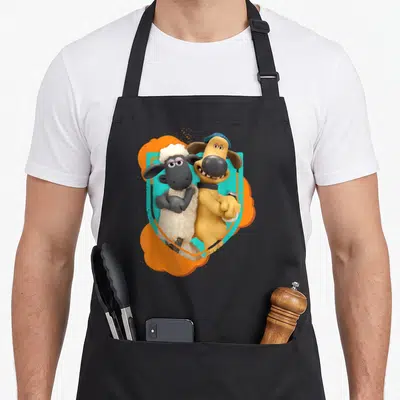Bitzer sheep apron - White sheep and yellow dog with blue hat against orange teal background — shown on a black cotton canvas apron against a white background
