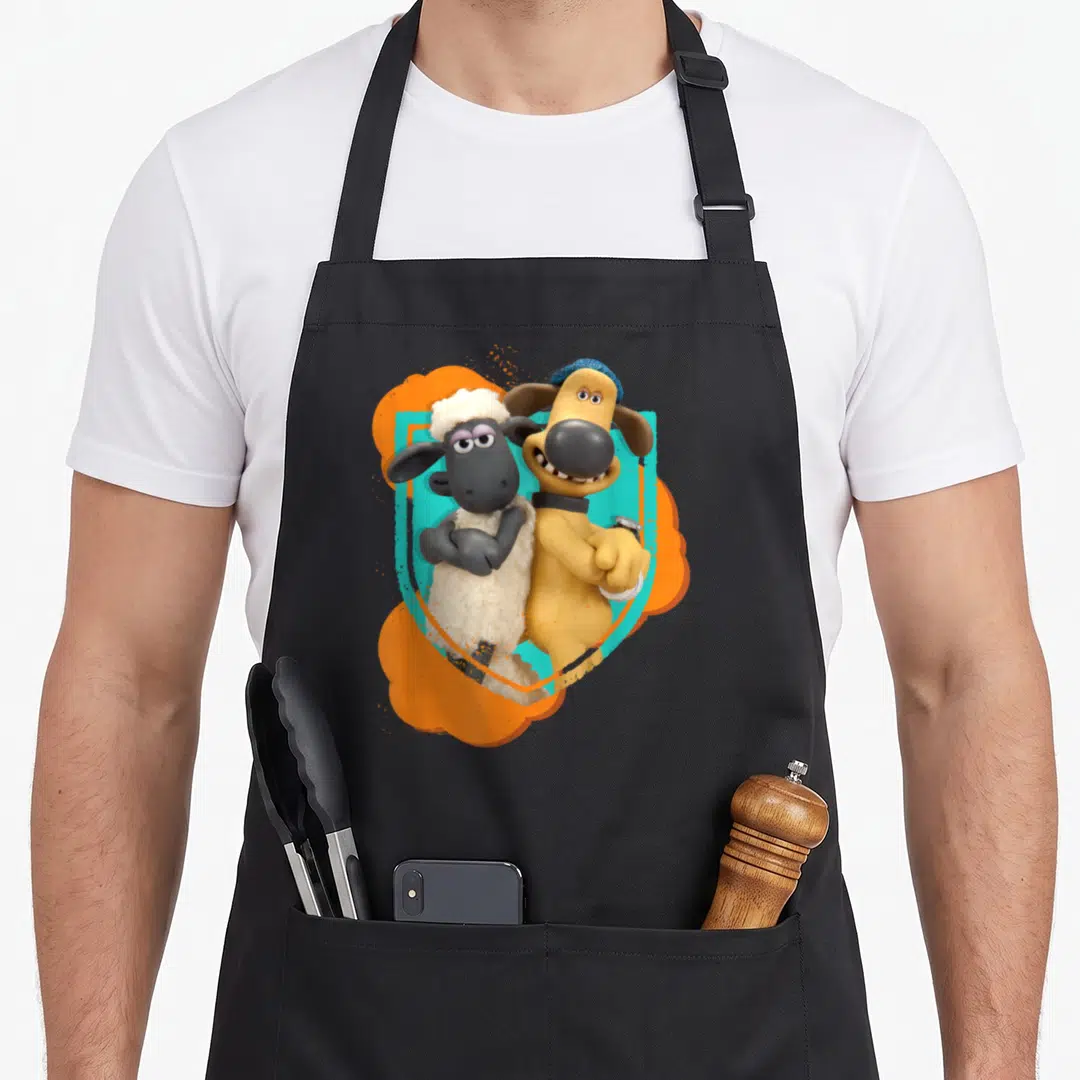 Bitzer sheep apron - White sheep and yellow dog with blue hat against orange teal background — shown on a black cotton canvas apron against a white background