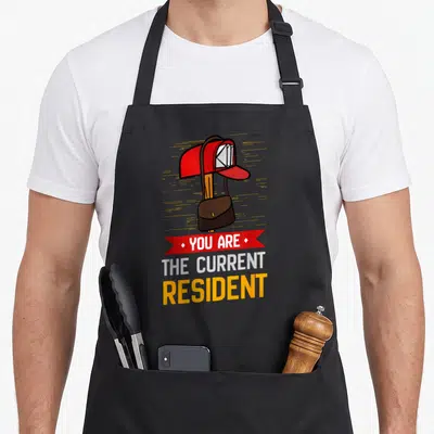 Current postal aprons - Red mailbox brown bag YOU ARE THE CURRENT RESIDENT cartoon graphic — shown on a black cotton canvas apron against a white background