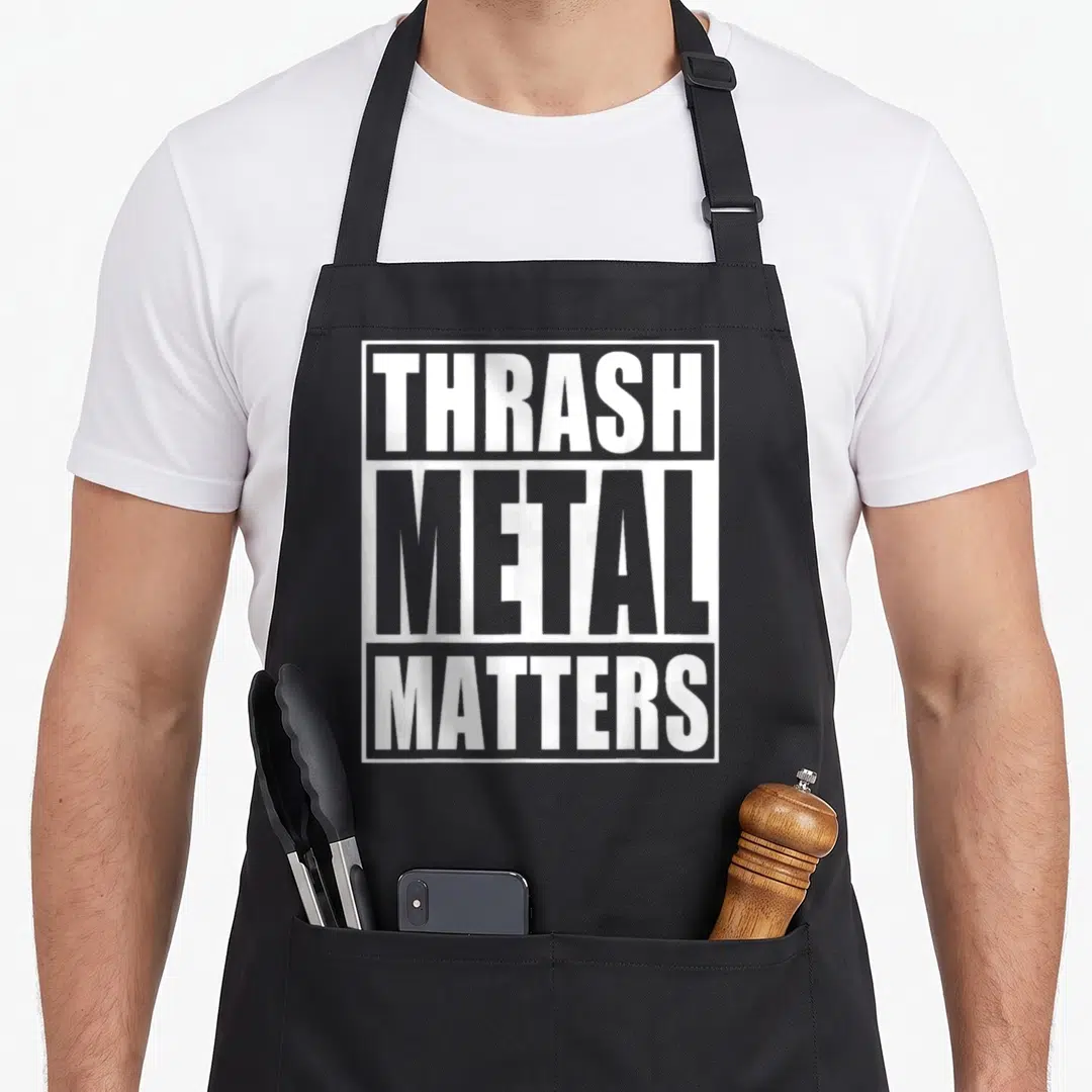 Metal thrash apron - White stacked text THRASH METAL MATTERS inside a rectangular border on grey background — shown on a black cotton canvas apron against a white background