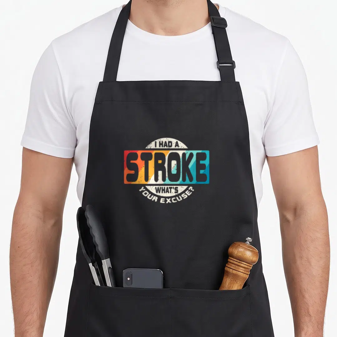 Cute survivor stroke awareness apron - I HAD A STROKE WHAT'S YOUR EXCUSE text in retro striped rectangle with arched — shown on a black cotton canvas apron against a white background