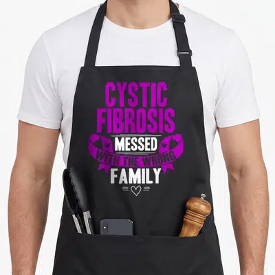 Funny cystic fibrosis awareness apron - Purple ribbon and stacked text reading Cystic Fibrosis Messed With The Wrong — shown on a black cotton canvas apron against a white background