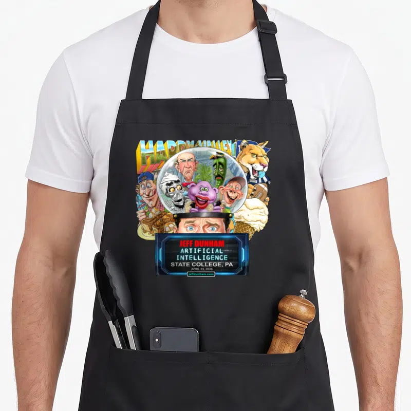 Jeff state college apron - Ventriloquist puppets in glass dome HAPPY VALLEY text Jeff Dunham Artificial Intelligence — shown on a black cotton canvas apron against a white background