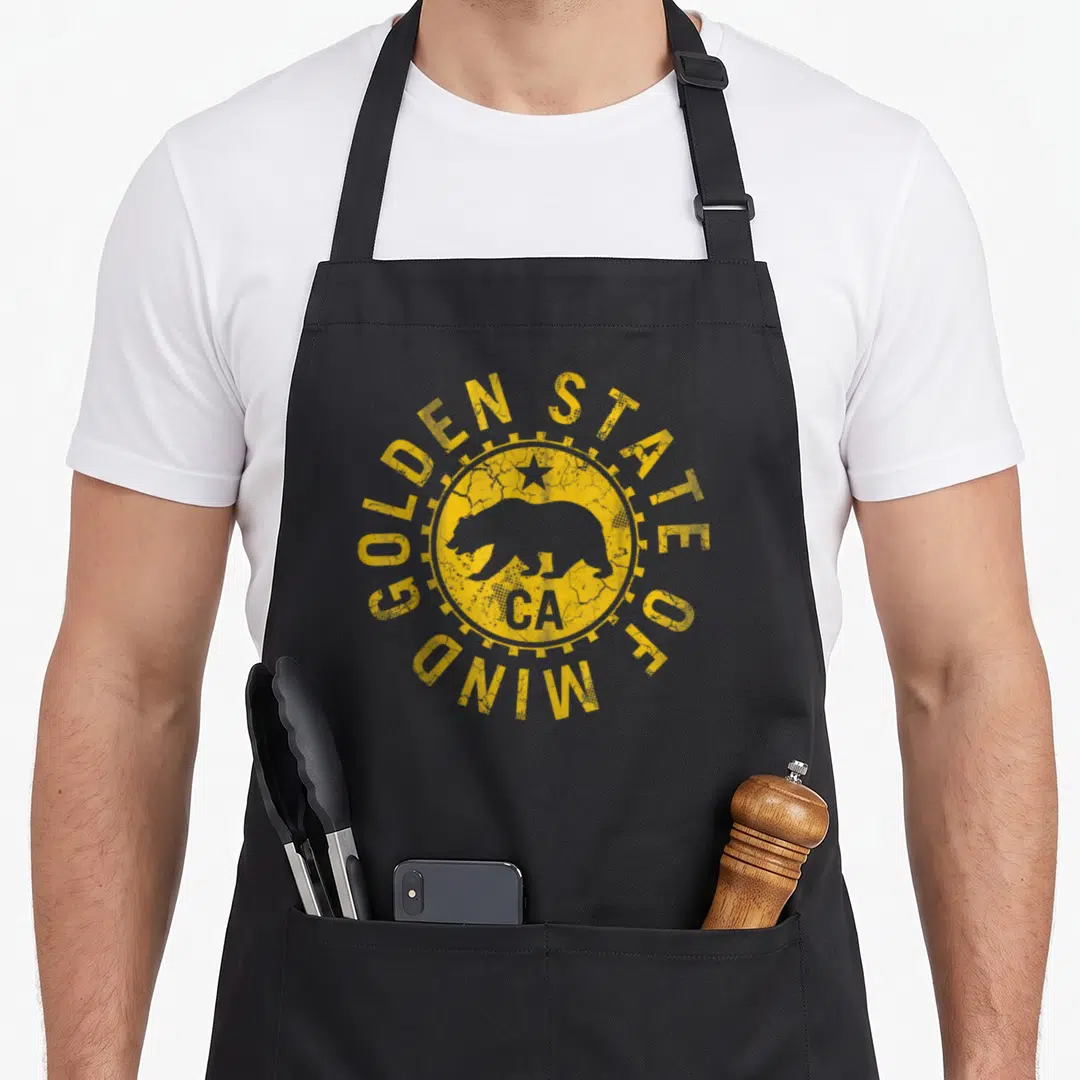 California golden apron - Distressed yellow circle with bear silhouette and Golden State of Mind text — shown on a black cotton canvas apron against a white background