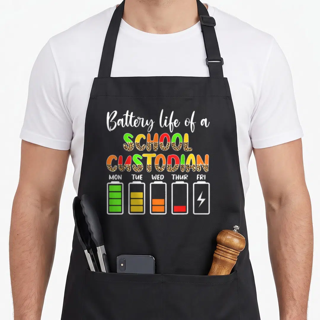 Battery janitor apron - Cartoon battery icons labeled Mon through Fri showing decreasing energy levels with colorful — shown on a black cotton canvas apron against a white background