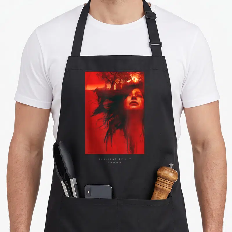 Funny biohazard apron - Red photo of crying woman with monster hand and tree landscape above white RESIDENT EVIL 7 text — shown on a black cotton canvas apron against a white background