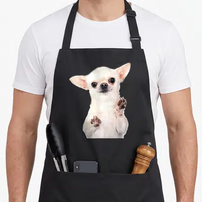 Chihuahua custom pet apron - Cream chihuahua dog facing forward with brown paw pads raised — shown on a black cotton canvas apron against a white background