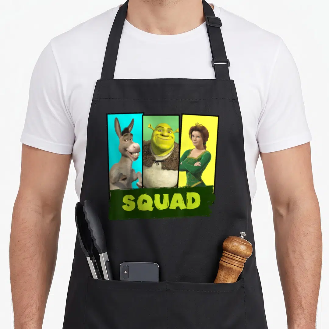 Shot squad apron - Shrek Donkey Fiona in vertical panels with SQUAD text on green brush stroke — shown on a black cotton canvas apron against a white background