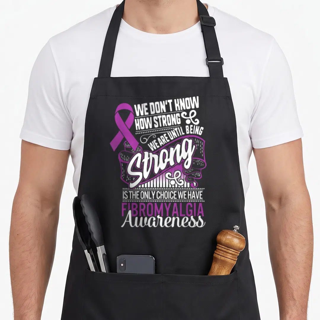 Strong choice aprons - Purple awareness ribbon next to stacked white and purple typography reading We Don't Know How — shown on a black cotton canvas apron against a white background