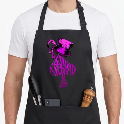 Hat alice wonderland apron - Magenta top hat above ace of spades with WE'RE ALL MAD HERE text — shown on a black cotton canvas apron against a white background