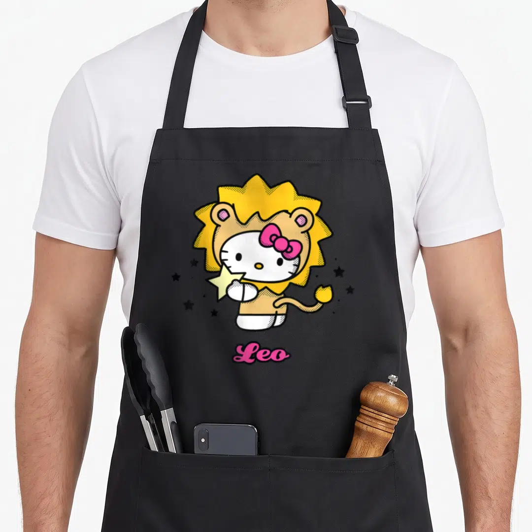 Leo zodiac aprons - Hello Kitty in yellow lion costume holding star with pink Leo text — shown on a black cotton canvas apron against a white background