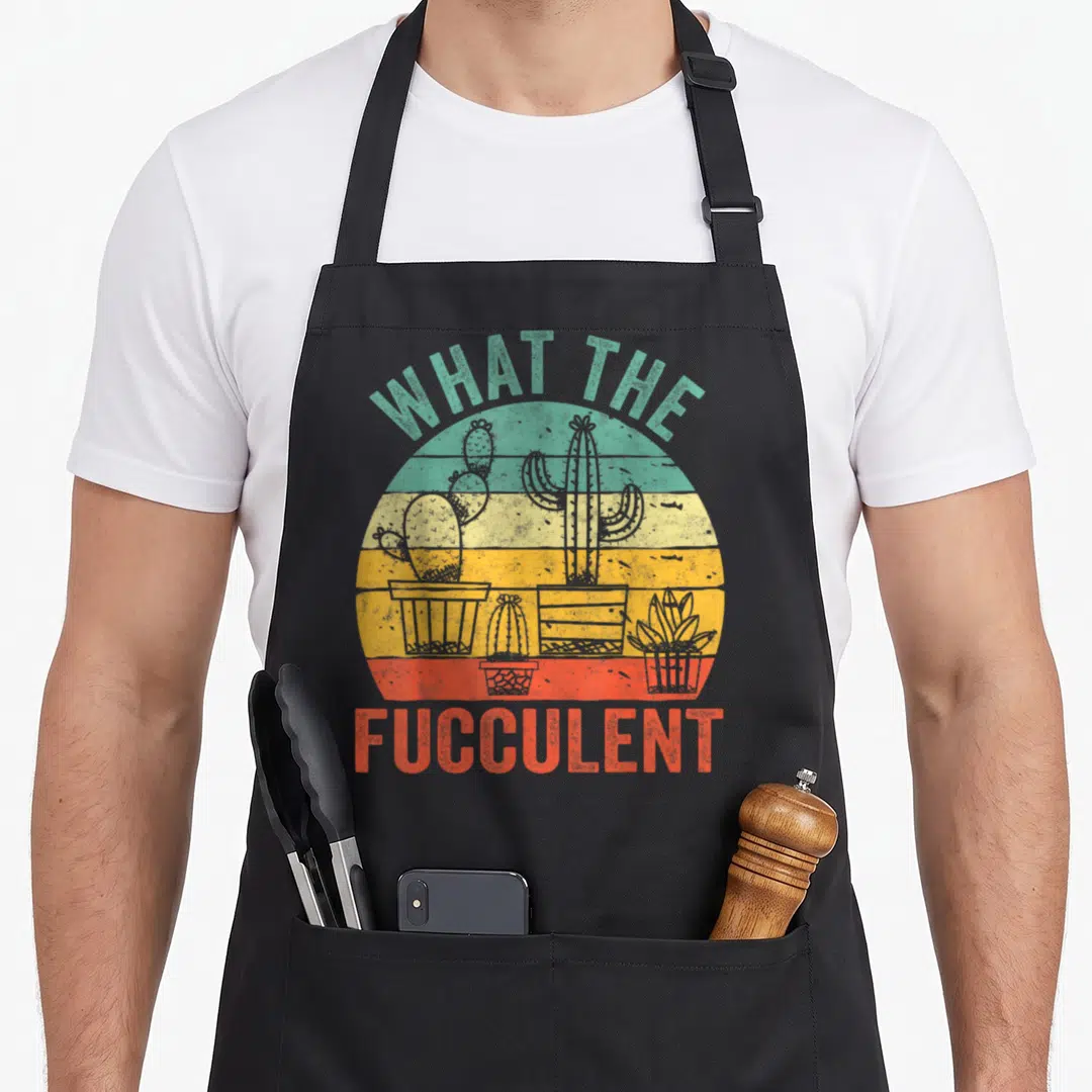 Fucculent succulent cactus apron - Retro sun with three potted cacti and text WHAT THE FUCCULENT in teal and red — shown on a black cotton canvas apron against a white background