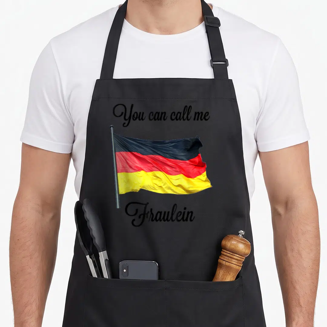 Call german apron - Waving German flag in black red yellow with You can call me Fraulein text — shown on a black cotton canvas apron against a white background