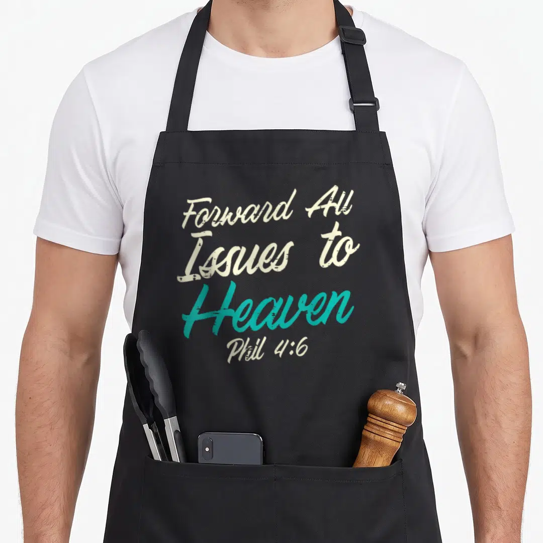 Catholic bible verse apron - Stacked Forward All Issues To Heaven Phil 4:6 text in off-white and teal script — shown on a black cotton canvas apron against a white background