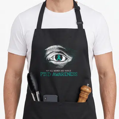 Suicide military apron - Line art eye with teal ribbon and PTSD awareness text — shown on a black cotton canvas apron against a white background