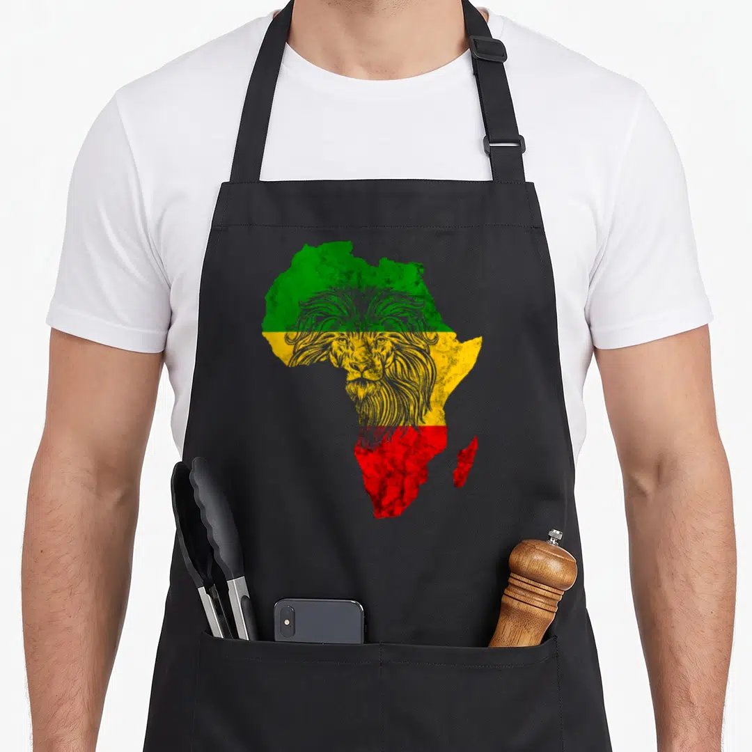 Coole lion apron - Lion head outline over Africa map with green yellow red stripes — shown on a black cotton canvas apron against a white background