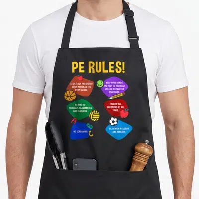 Teacher education apron - PE RULES text with six colored shapes listing gym rules and sports equipment icons — shown on a black cotton canvas apron against a white background