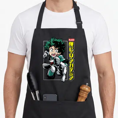 Deku anime apron - Izuku Midoriya running pose with red My Hero Academia box and vertical yellow Japanese text — shown on a black cotton canvas apron against a white background