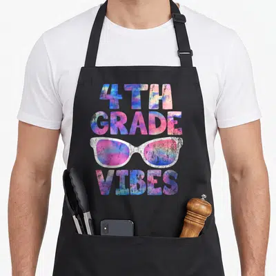4th teacher apron - Tie-dye 4th Grade Vibes text with sunglasses in pink blue purple white — shown on a black cotton canvas apron against a white background