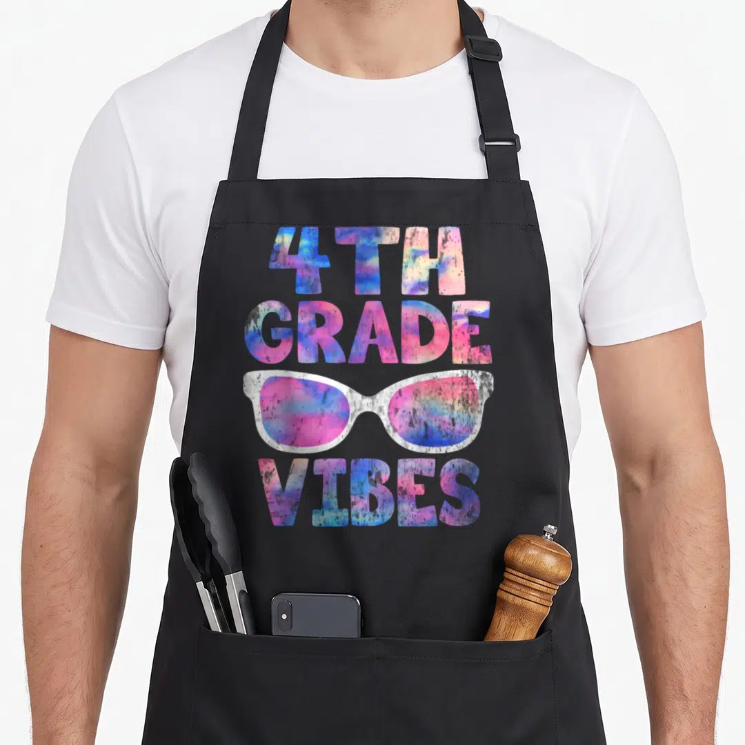 4th teacher apron - Tie-dye 4th Grade Vibes text with sunglasses in pink blue purple white — shown on a black cotton canvas apron against a white background