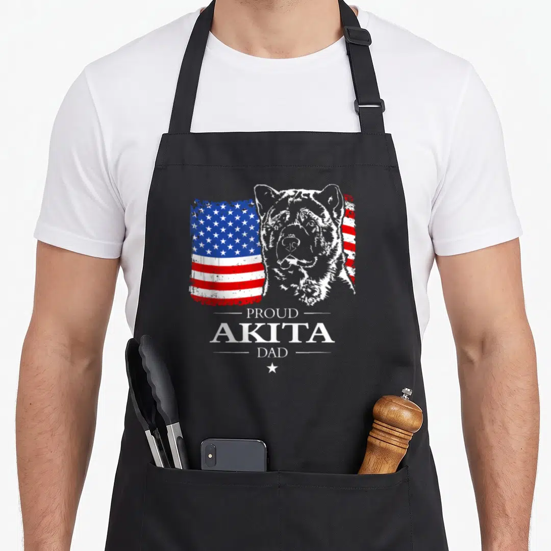 Akita american flag apron - Distressed US flag behind Akita head with Proud Akita Dad text and small star — shown on a black cotton canvas apron against a white background
