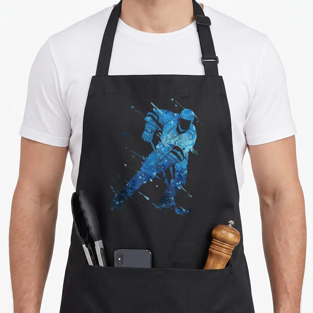 Ice wintersport hockey apron - Blue watercolor splatter silhouette of a hockey player holding a stick in action pose — shown on a black cotton canvas apron against a white background