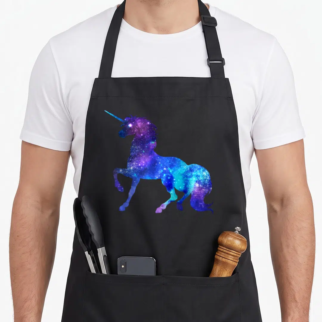 Galaxy unicorn apron - Rearing unicorn silhouette filled with blue purple and white galaxy star pattern — shown on a black cotton canvas apron against a white background