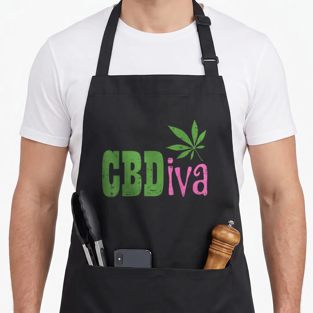 Cbdiva hemp apron - Green CBD and pink iva text with a cannabis leaf graphic — shown on a black cotton canvas apron against a white background