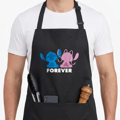 Angel stitch apron - Two cartoon characters in blue and pink sitting side-by-side above white FOREVER text — shown on a black cotton canvas apron against a white background