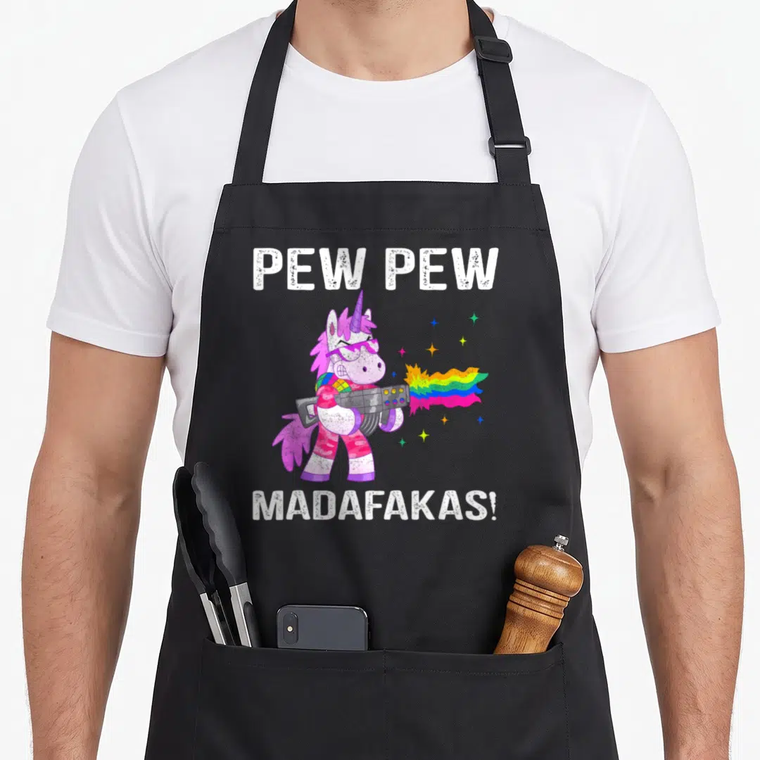 Unicorn black cat aprons - Cartoon unicorn in pink and purple firing a rainbow beam with white text — shown on a black cotton canvas apron against a white background
