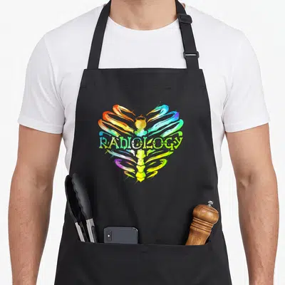 Ribcage radiology apron - Rainbow heart shaped rib cage with RADIOLOGY text in cartoon style — shown on a black cotton canvas apron against a white background
