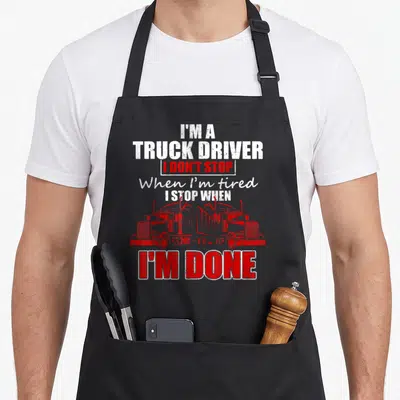 Cute driver semi truck apron - Two red semi trucks facing each other under stacked white and red text about stopping — shown on a black cotton canvas apron against a white background