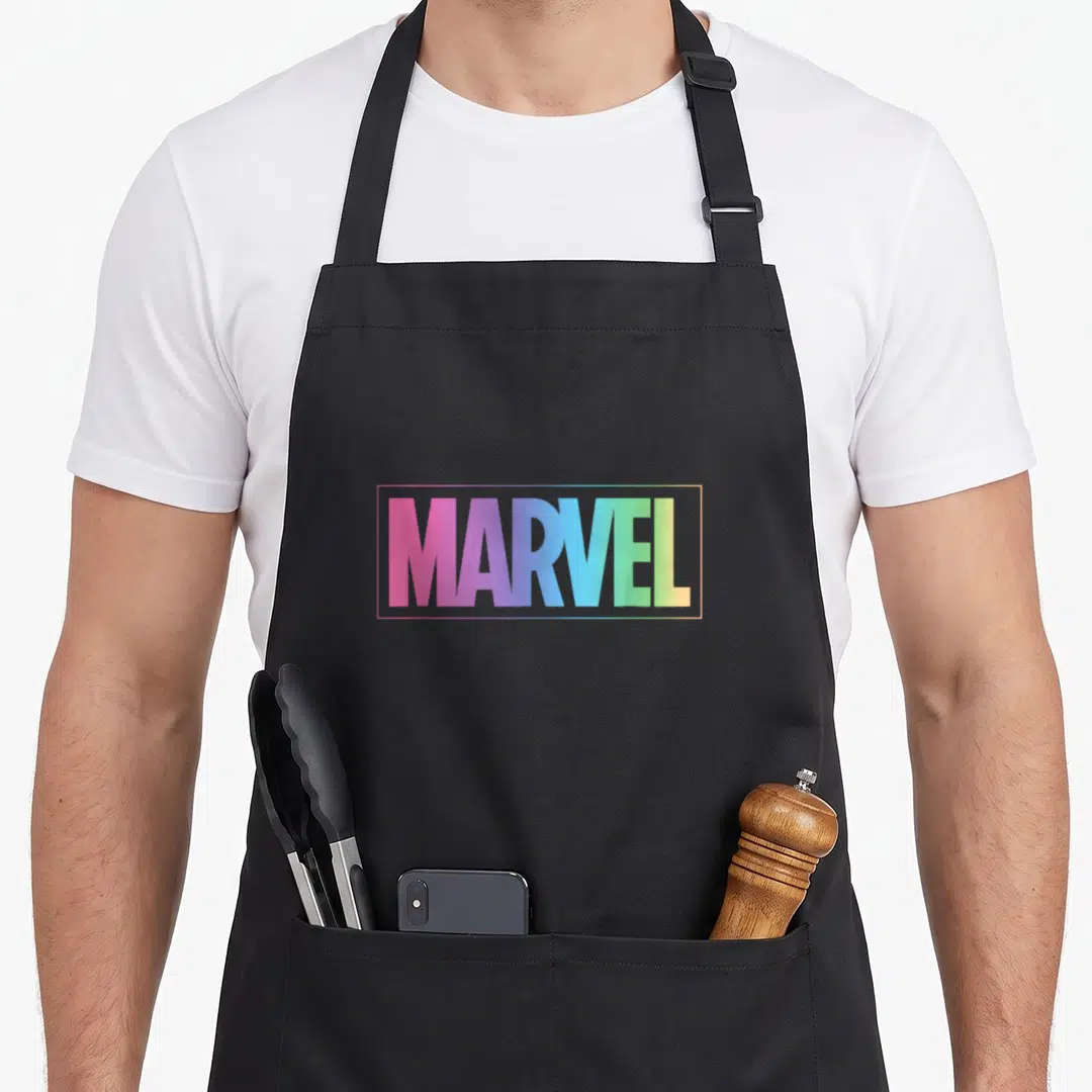 Pastel rainbow apron - MARVEL text in pink blue green yellow gradient inside rectangular border — shown on a black cotton canvas apron against a white background