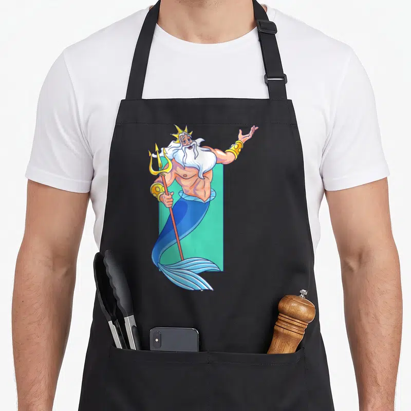 Portrait king apron - Cartoon Poseidon holding trident with raised arm against teal rectangle in blue gold and white — shown on a black cotton canvas apron against a white background