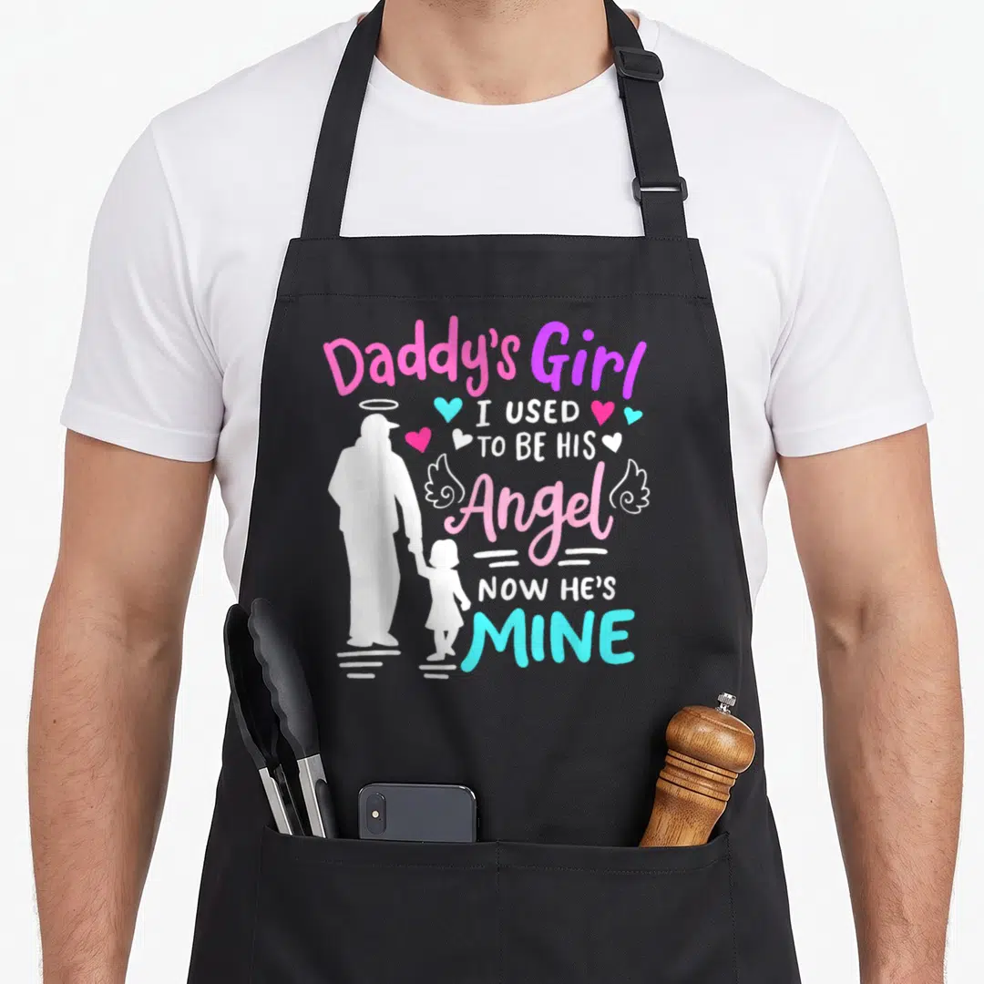Daddy angels and aprons - White father daughter silhouette with pink blue purple text reading I used to be his angel — shown on a black cotton canvas apron against a white background