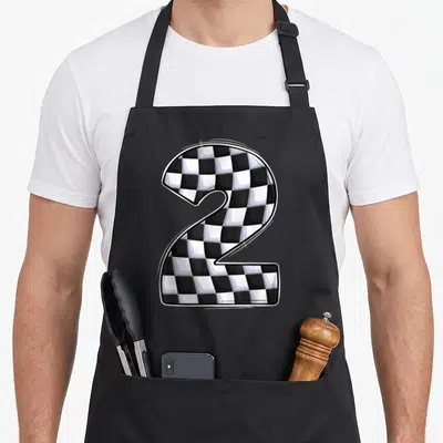 Crew 2nd apron - Cartoon number two filled with black and white checkered racing pattern — shown on a black cotton canvas apron against a white background