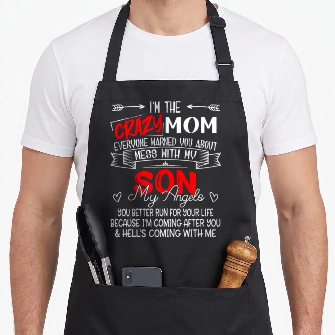 Mess mom and son aprons - Vertical white and red text reading Crazy Mom Mess With My Son with arrows ribbon and hearts — shown on a black cotton canvas apron against a white background