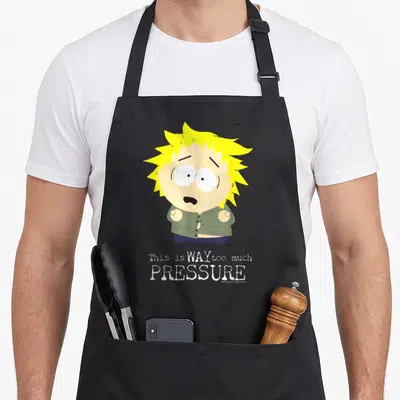 Tweek much apron - Stressed cartoon character with yellow hair and olive shirt above white text reading This is WAY too — shown on a black cotton canvas apron against a white background